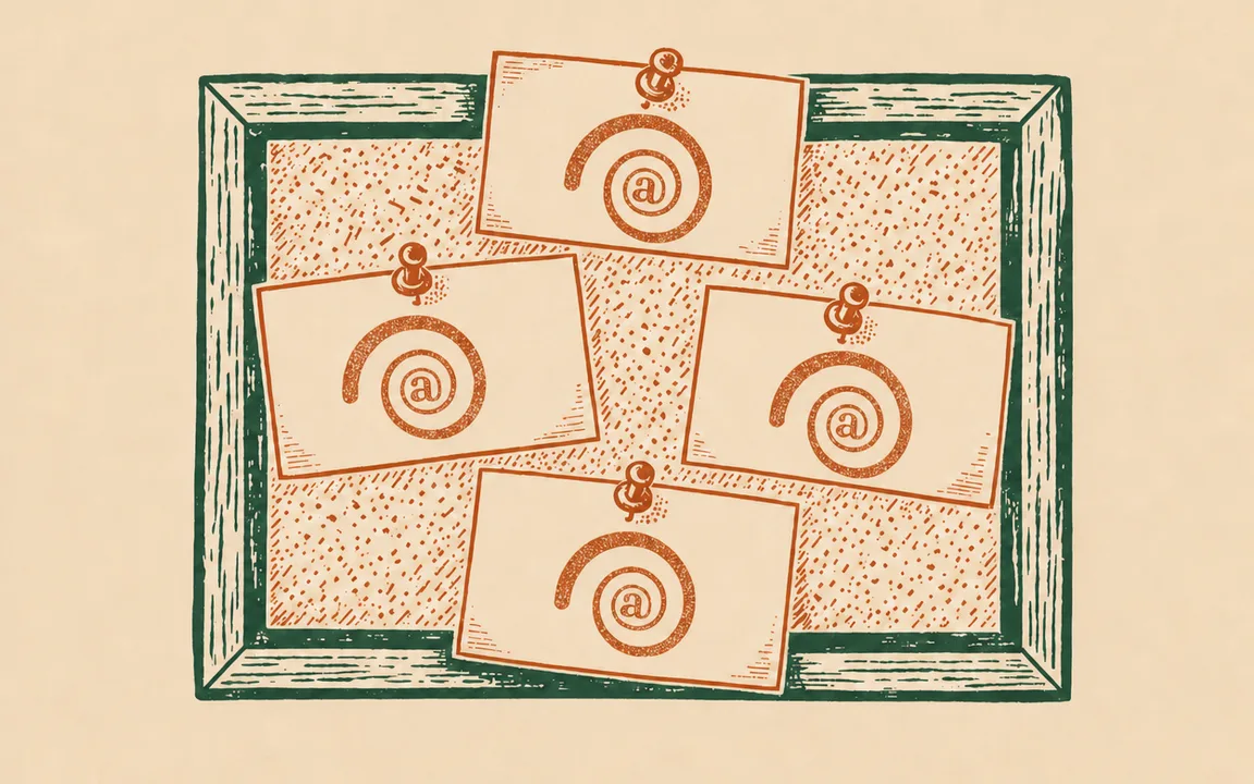 A wooden box filled with overlapping envelopes, each bearing an @ symbol and a small crab logo in the corner.