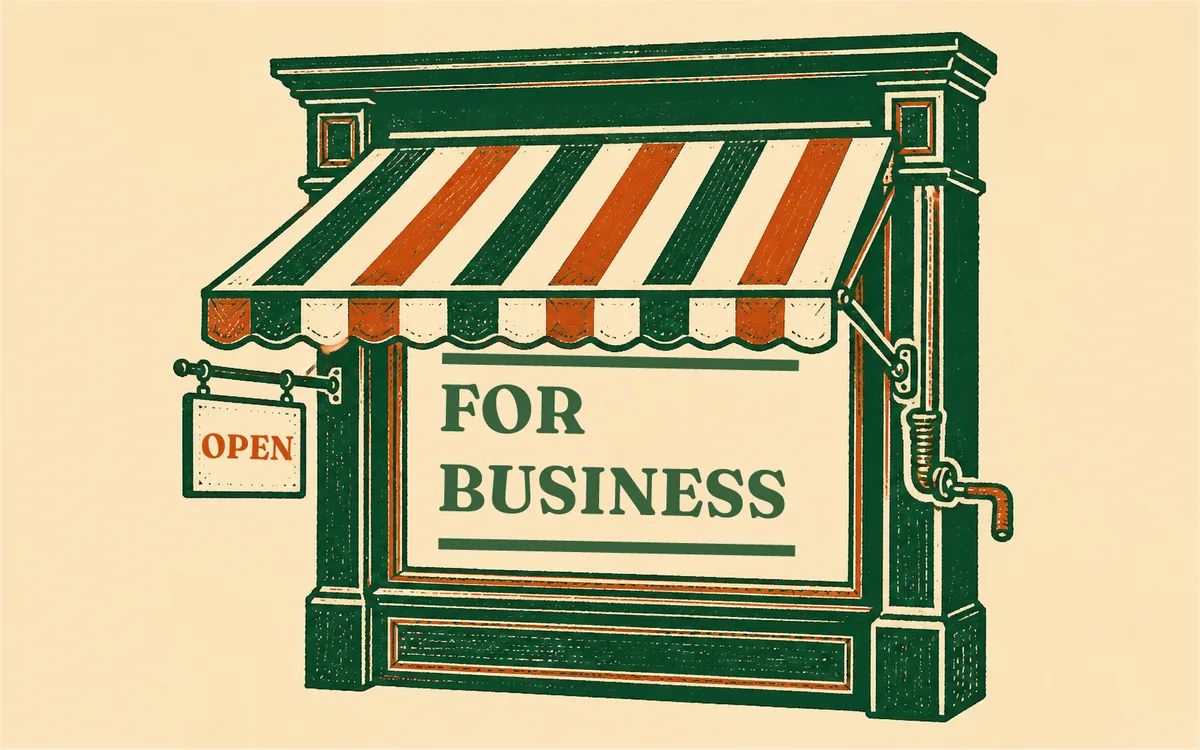 A striped shop awning over a window painted FOR BUSINESS, a hanging sign reading OPEN